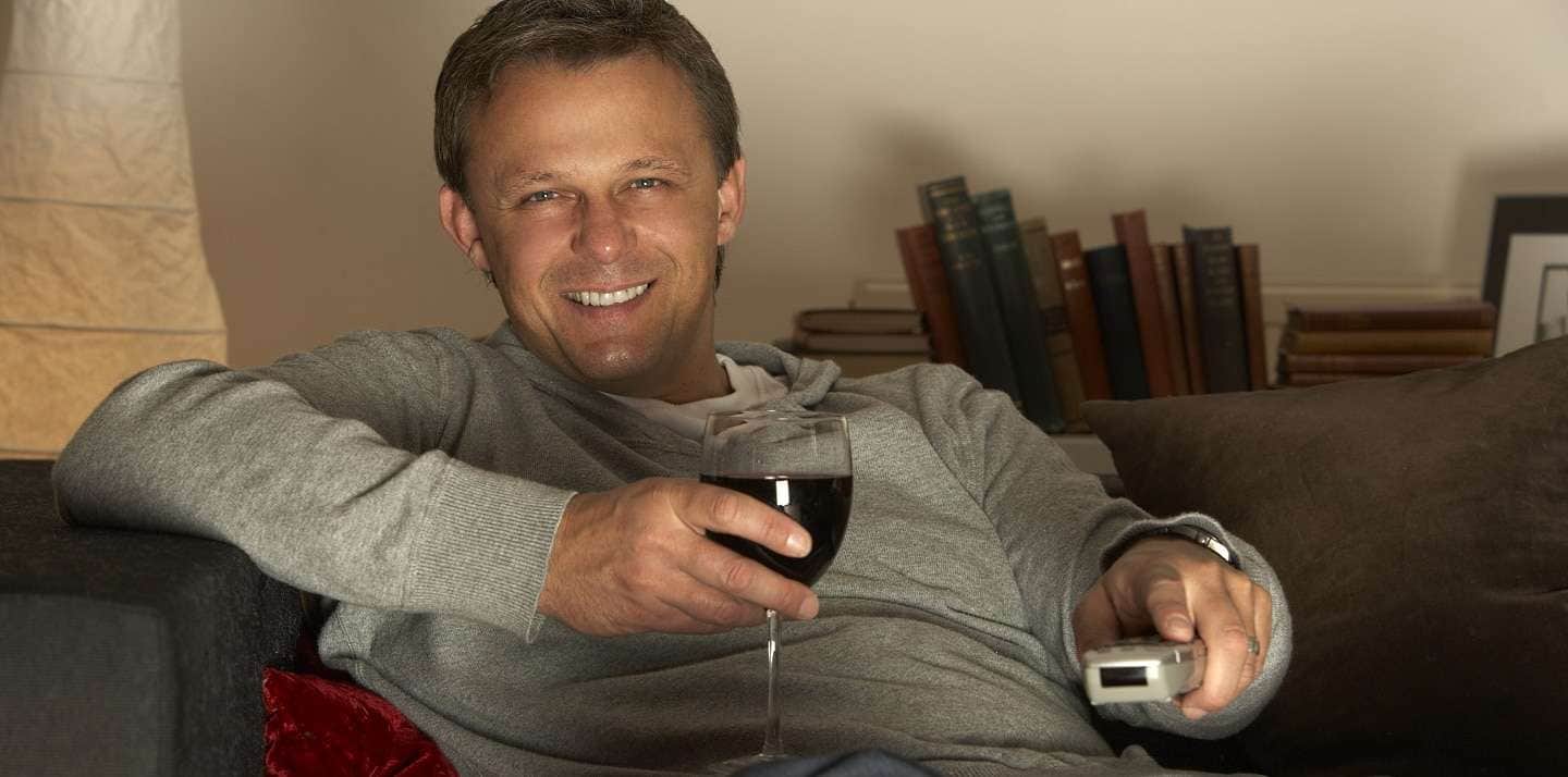 vinfilmer - kille ser på tv med vinglas