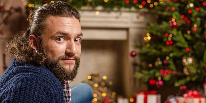 julklappar - snygg kille framför granen