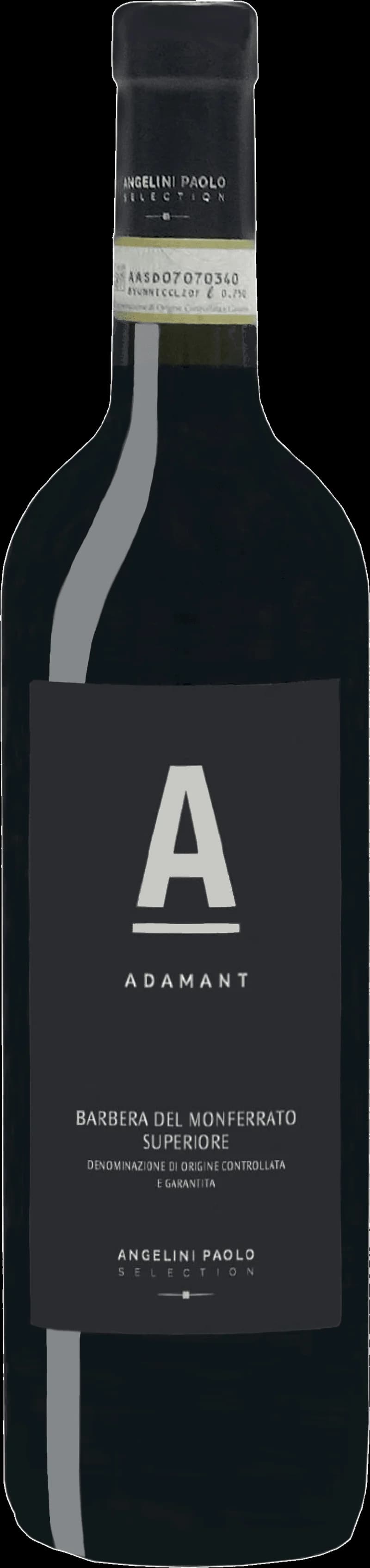 Flaska med Adamant rött vin på ett bord med vinglas i bakgrunden.