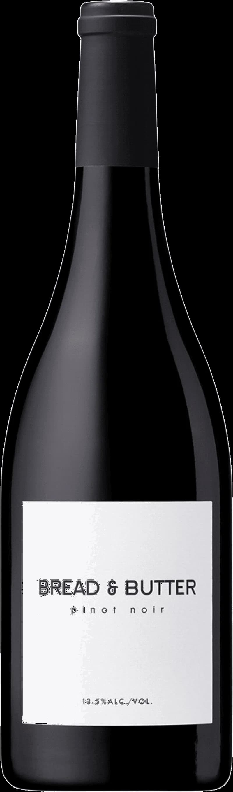 Ett glas rött vin bredvid en bit bröd med smör på en träbricka.