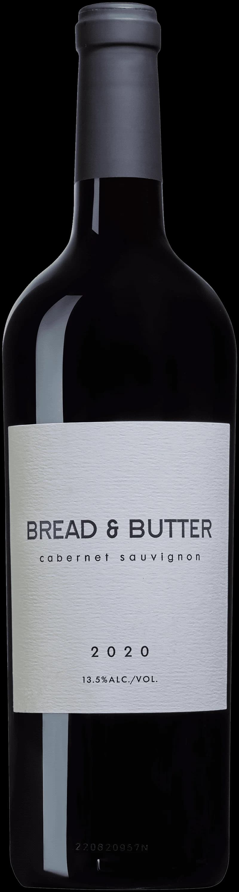 En bit bröd med smör bredvid ett glas rött vin på en träbänk.