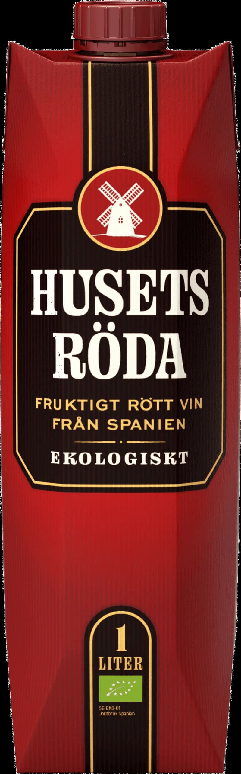 Ett glas rött vin på ett bord med flaska i bakgrunden