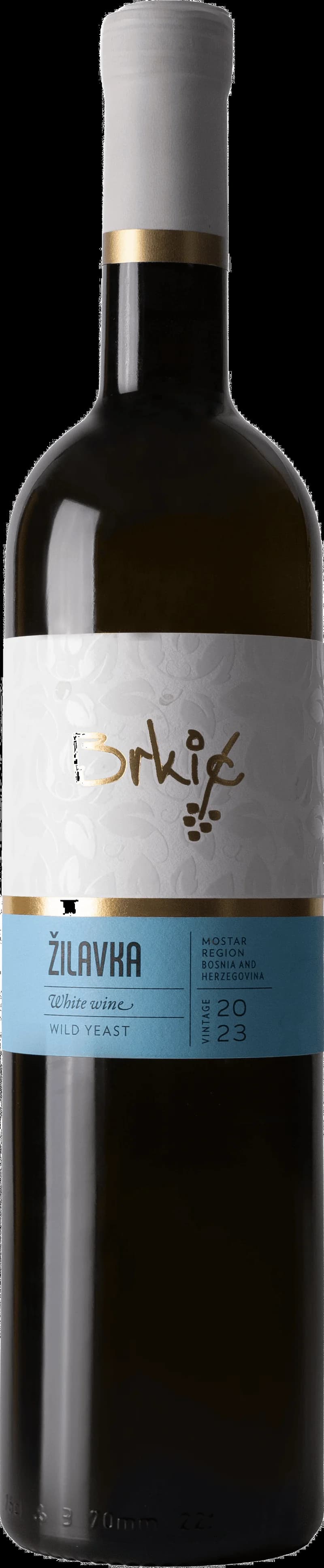 Flaska Ilavka vitt vin på ett bord med glas i bakgrunden.