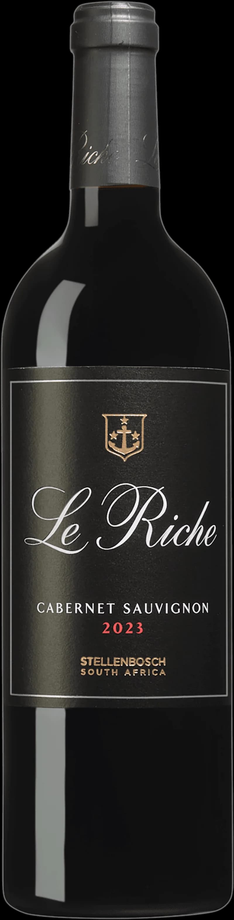 Flaska av Le Riche rött vin mot en mörk bakgrund.