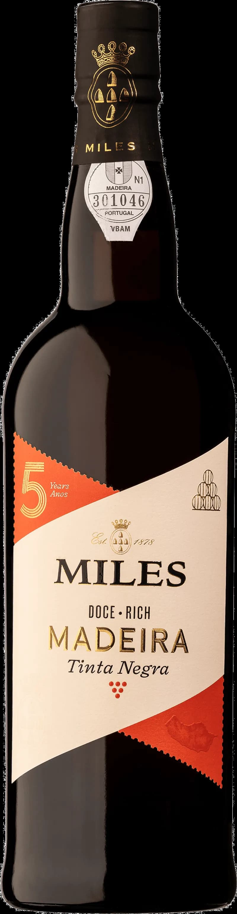 Flaska av Miles starkvin med etikett och röd vätska i glas