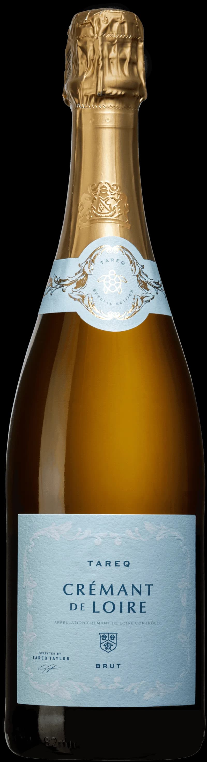 Tareq Taylor håller ett glas mousserande vin framför en bakgrund av bubbel.