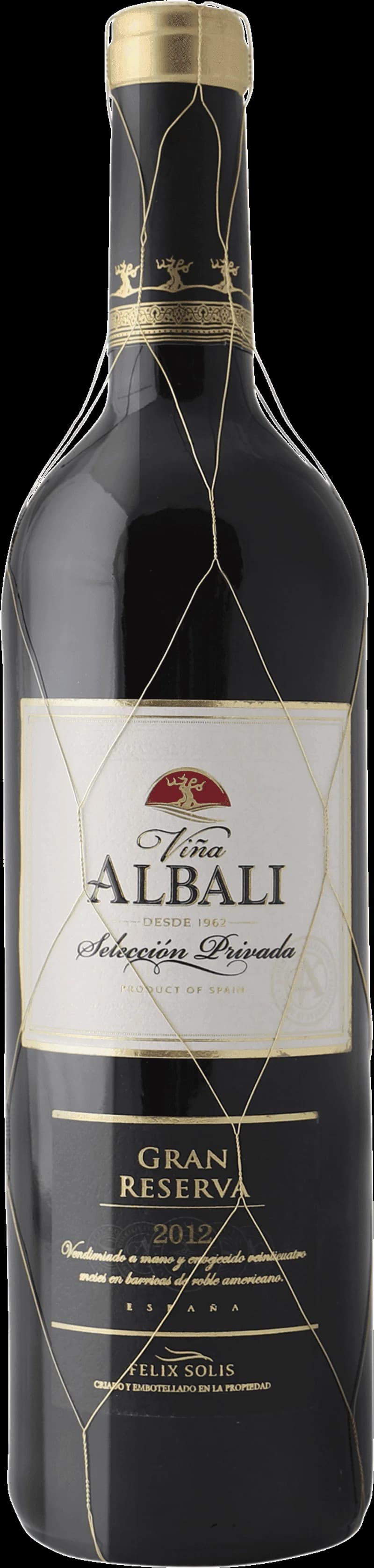 Flaska och glas med Viña Albali rött vin på ett bord.