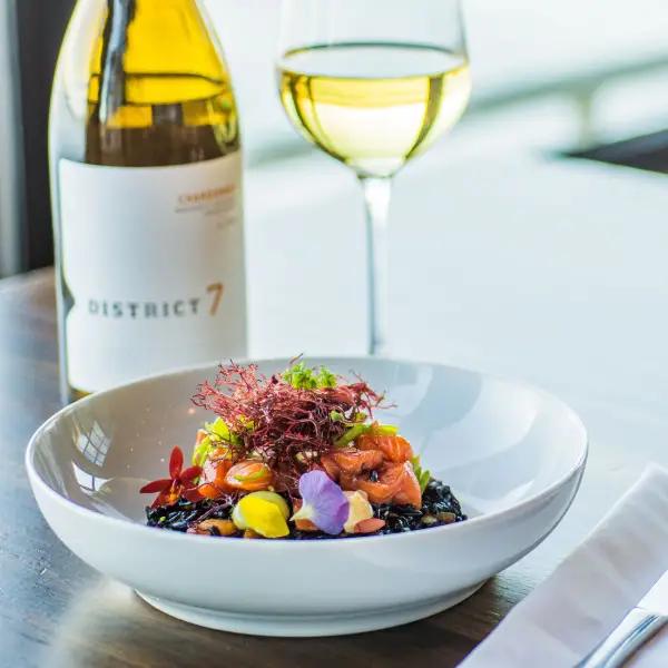en flaska D7 Chardonnay och en tallrik med sallad