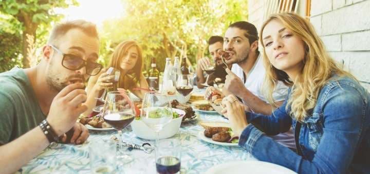 sommarviner en grupp männniskor vid ett bord ute och äter