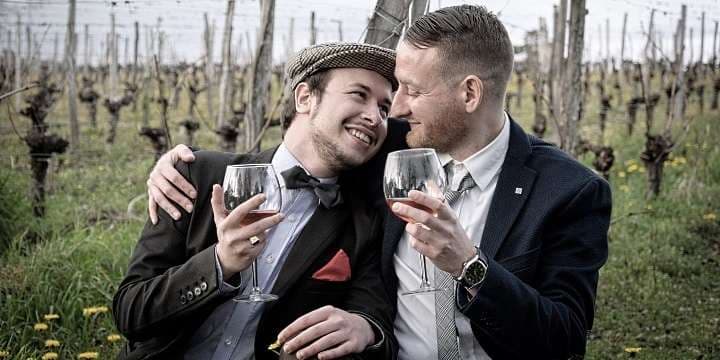 2 killar som kramas och skålar i vin