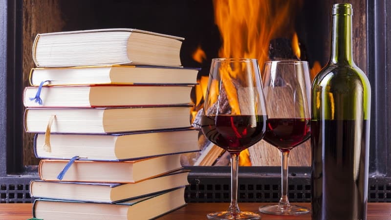 julböcker bok och vin framför brasan