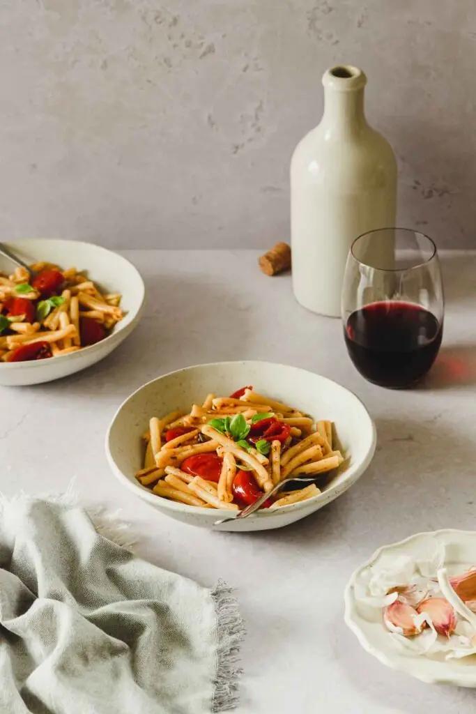 glass of red wine plate pasta tomato rustic rosemary
