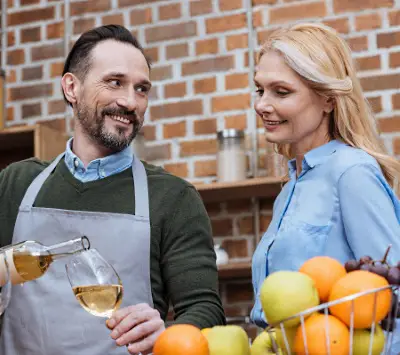 ett par som tar ett glas vin i köket