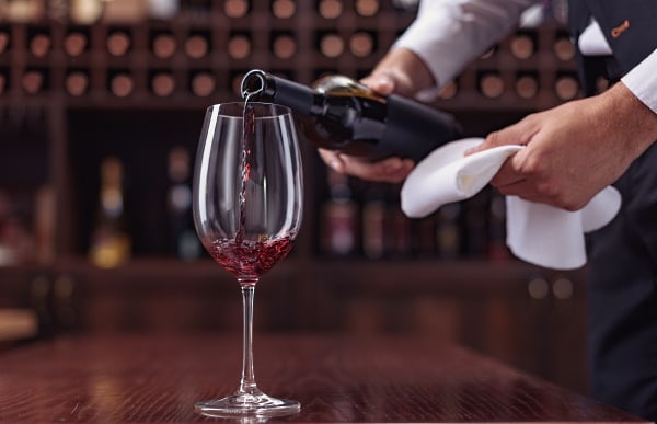 dekantera - en man som häller vin i ett glas