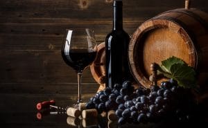 vinflaska, fat och röda druor