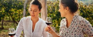 eleganta viner - två kvinnor på uteplatsen dricker vin