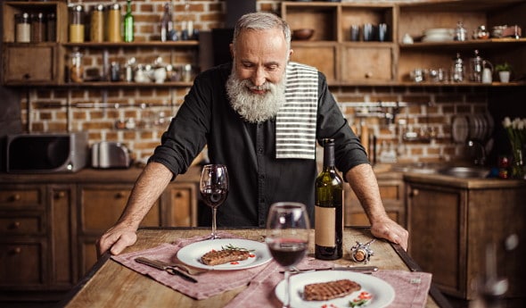 franska höstviner - en man som dukar med vin om mat i köket