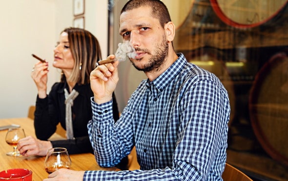 konjaksvärlden - ett par dricker konjak och röker cigar